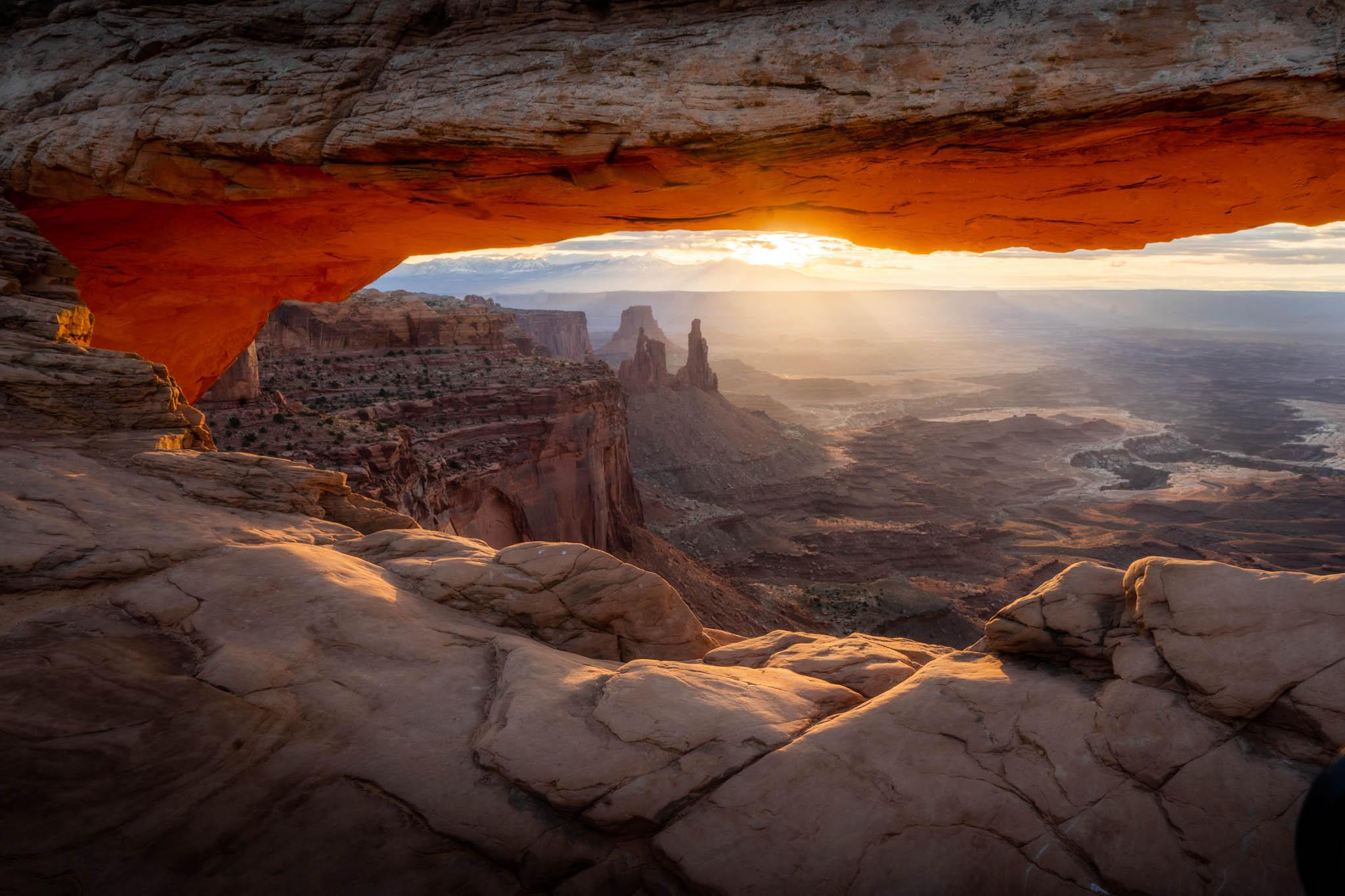 a wide view of a desert landscape with rock formations at sunset